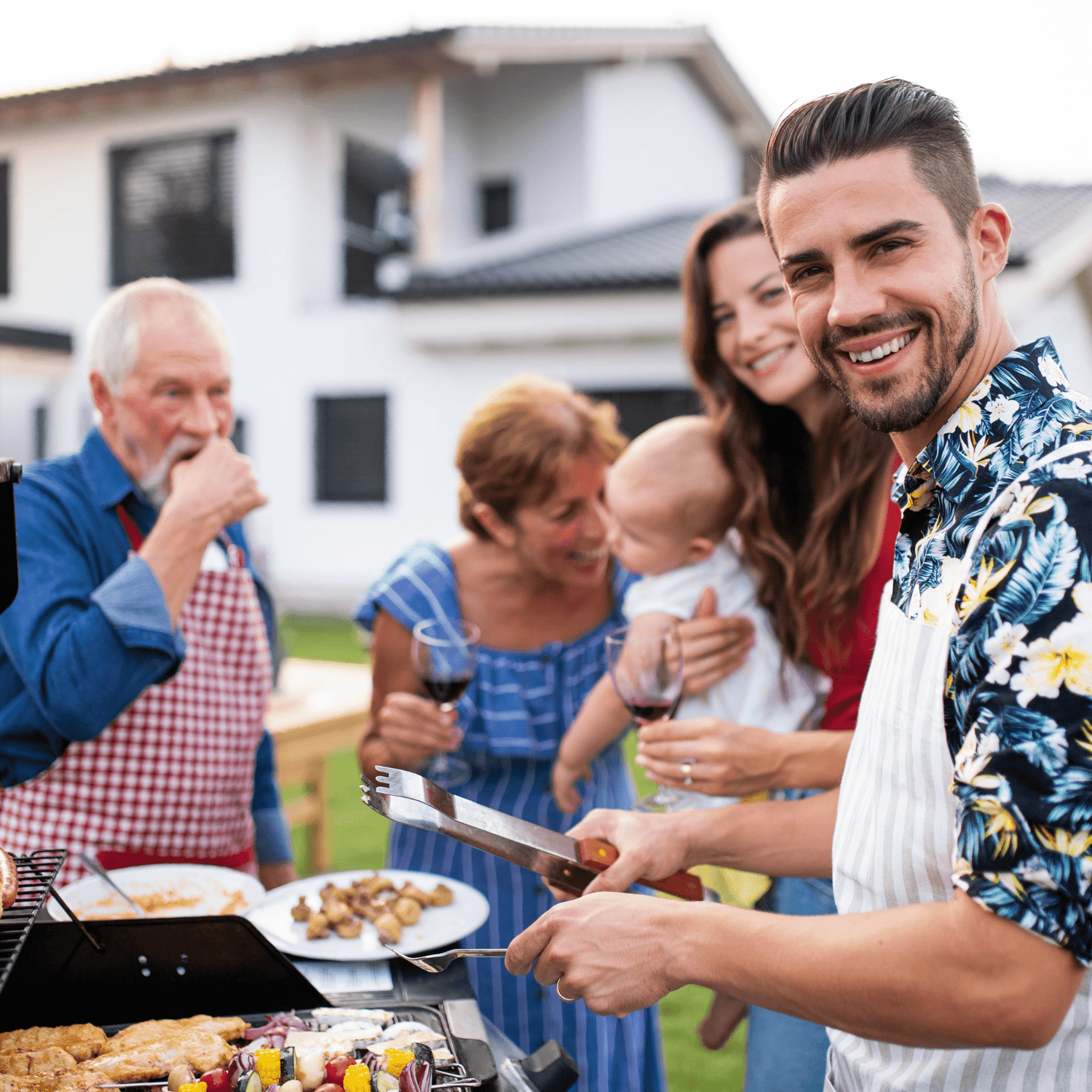 a group of people standing around a barbecue grill