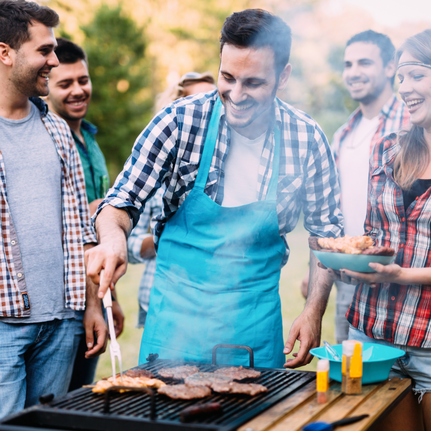 a group of people cooking meat on a grill
