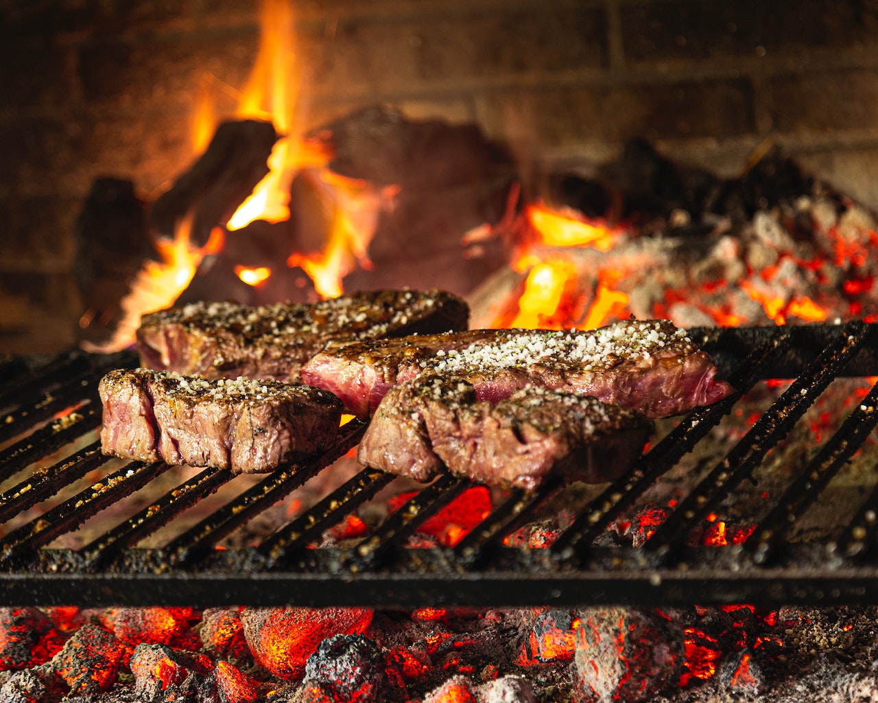 steak on a grill with a fire in the background